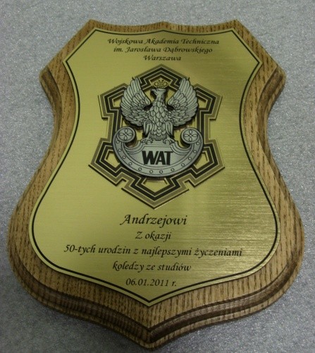 Pamitki, upominki nr 49 Pamiatka grawerowana w laminacie metalizowanym na podkadzie drewnianym logo WAT jako nakadka